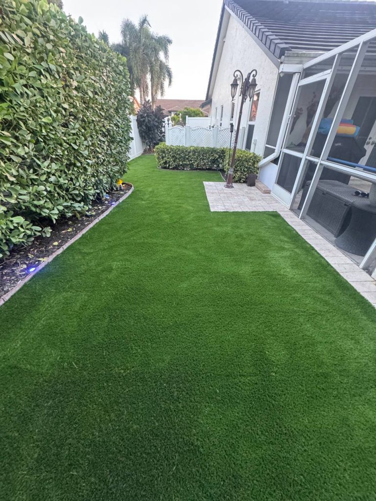 Turf beside a hedge and screened patio.