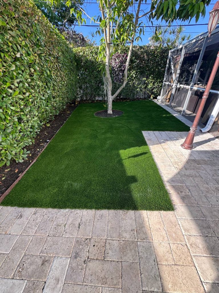 Turf beside a hedge and screened patio.