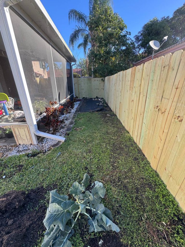 Earlier ground surface beside a two-storey beige house and screened patio.
