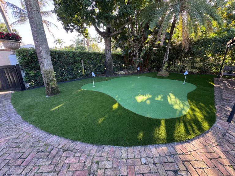 Putting green with small flags, palm trees and surrounding brick paths.
